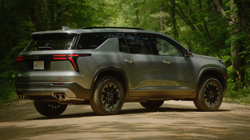 Side view of the 2025 Chevrolet Traverse SUV parked alone in a forest.