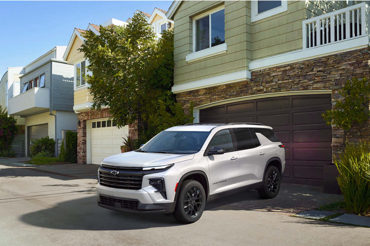 Front-side view of the 2025 Chevrolet Traverse SUV parked outside a house.