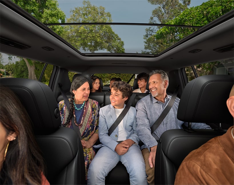Front view of the interiors of the 2025 Chevrolet Traverse SUV with all the seats occupied by people.