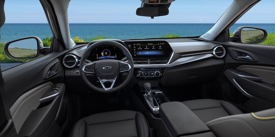 Front dashboard, steering wheel, and touchscreen display inside the 2025 Chevrolet Trax.