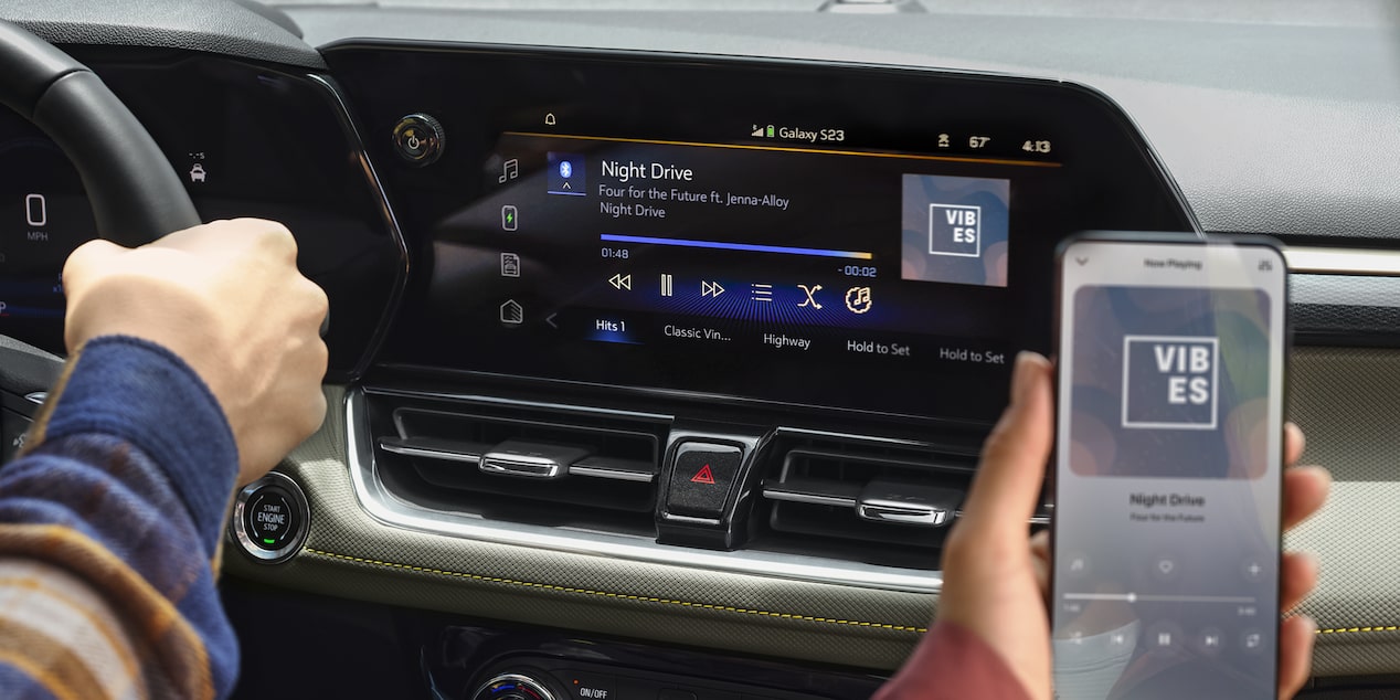 A passenger seated at the front row using a smartphone inside the 2026 Chevrolet Trailblazer.