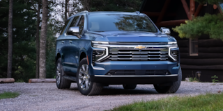 Birds-Eye Side View of the 2025 Chevrolet Tahoe SUV Driving on a Road