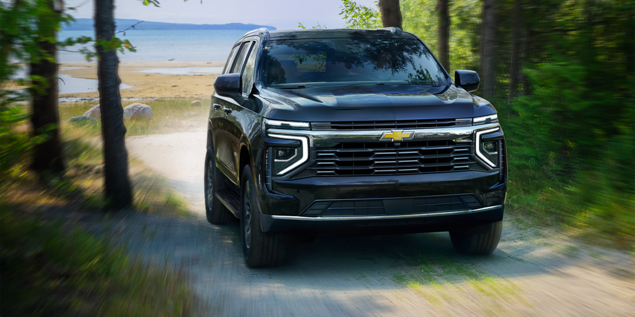 Front-side view of the 2025 Chevrolet Tahoe SUV driving alone on a gravel path.