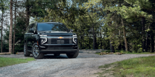 Front Three-Quarters View of the 2025 Chevrolet Suburban SUV Parked in a Wooded Area