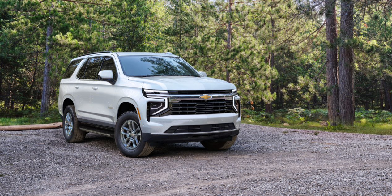 Front-side view of the 2025 Chevrolet Tahoe SUV parked alone in a wooded area.