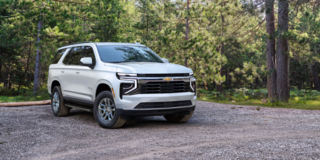 Front Three-Quarters View of the 2025 Chevrolet Suburban SUV Parked in a Wooded Area