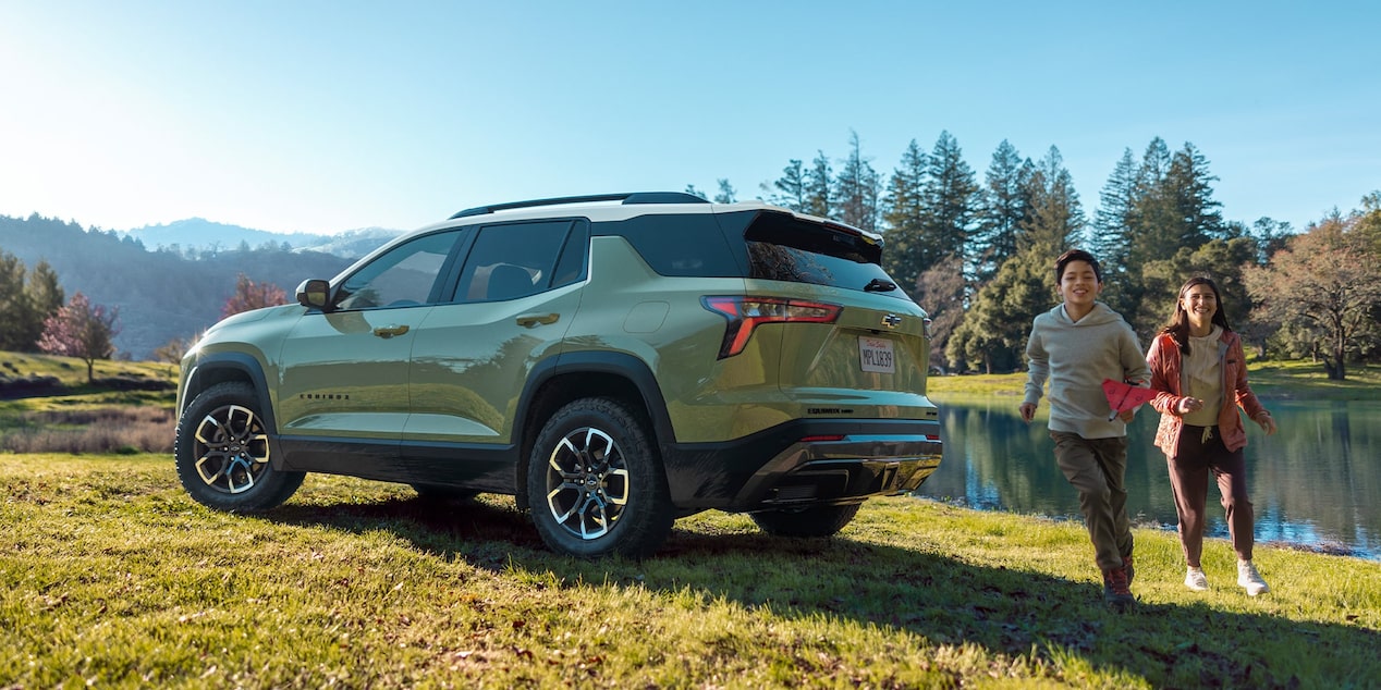 Deux personnes passent à côté d’un Chevrolet Equinox 2026 stationné à l’extérieur.