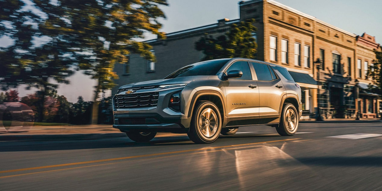 Vue latérale avant du Chevrolet Equinox LT 2026 en mouvement en ville.