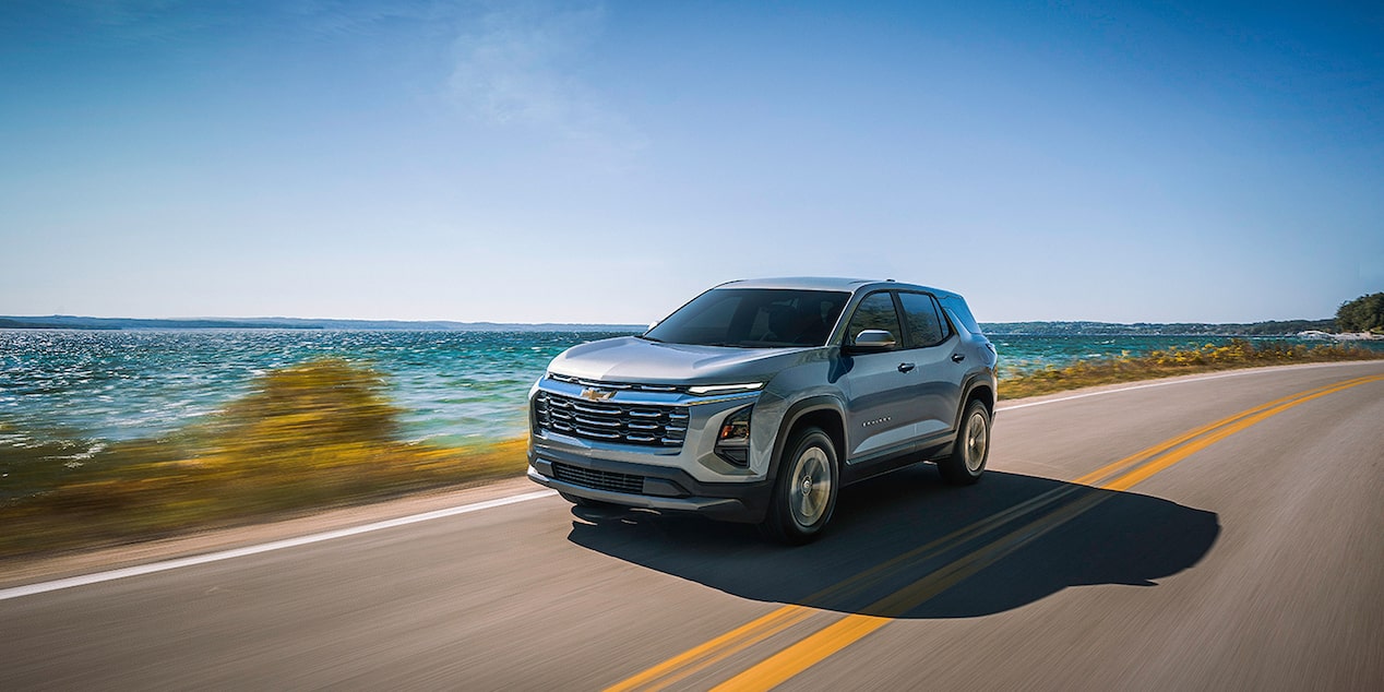 Un Chevrolet Equinox LT 2026 en mouvement sur une route au bord de la mer.