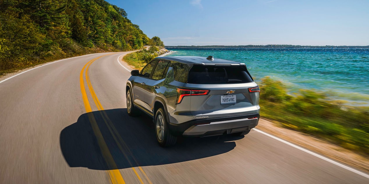 Back-side view of the 2026 Chevrolet Equinox driving on a seaside road.