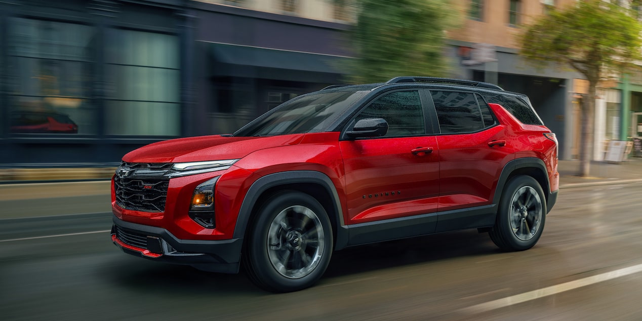 Vue latérale avant du Chevrolet Equinox 2026 en mouvement en ville.