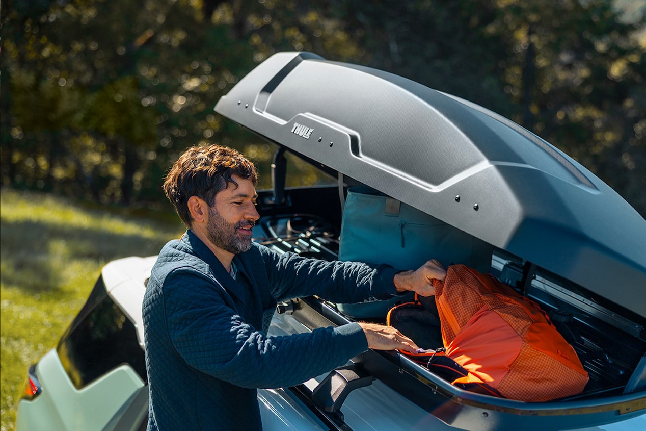 A person stowing bags on the trunk of the 2026 Chevrolet Equinox.