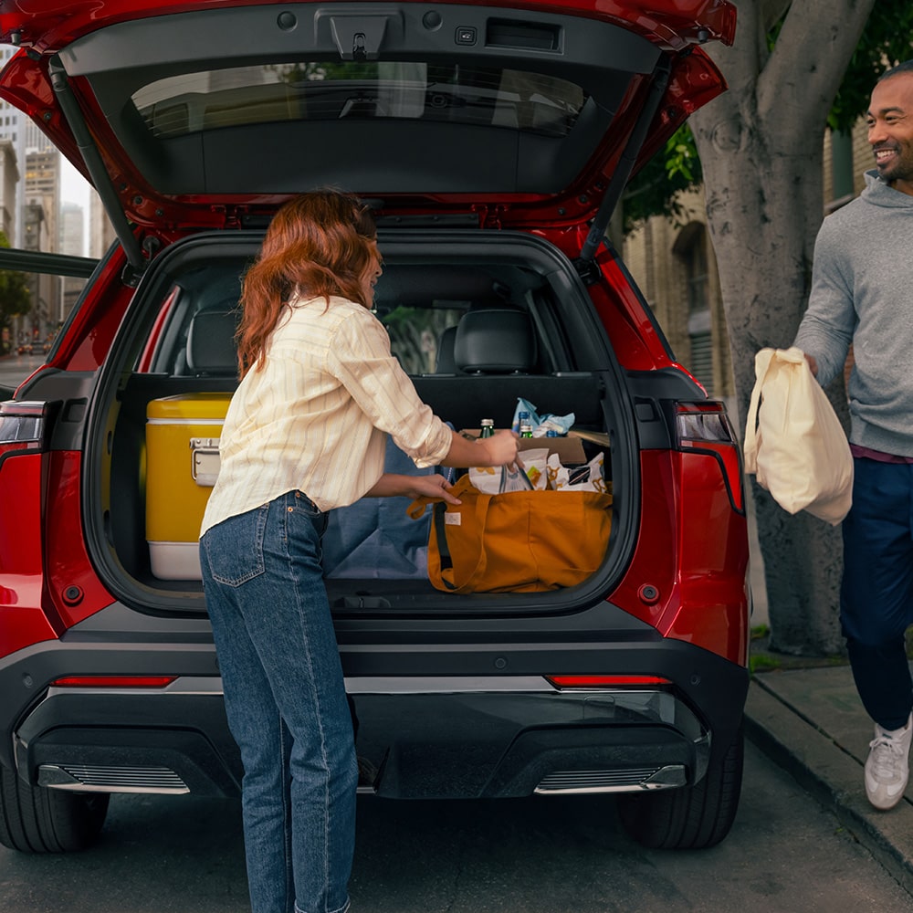 A person stowing belongings on the trunk of the 2026 Chevrolet Equinox.