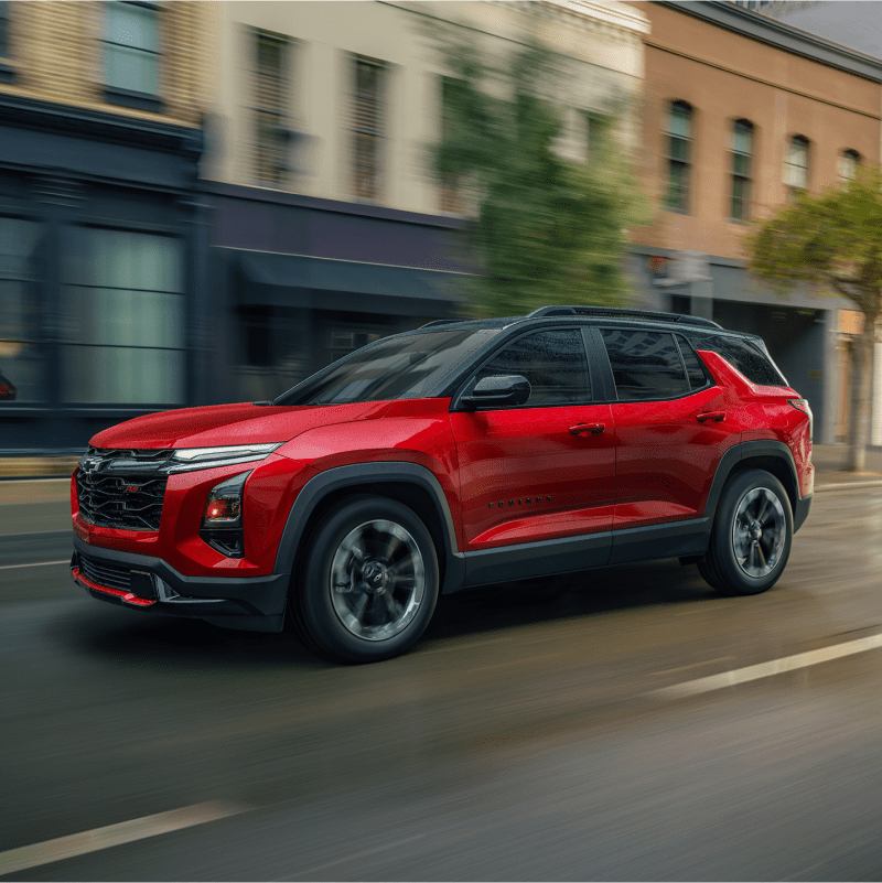Front-side view of the 2026 Equinox driving fast alone in the city.