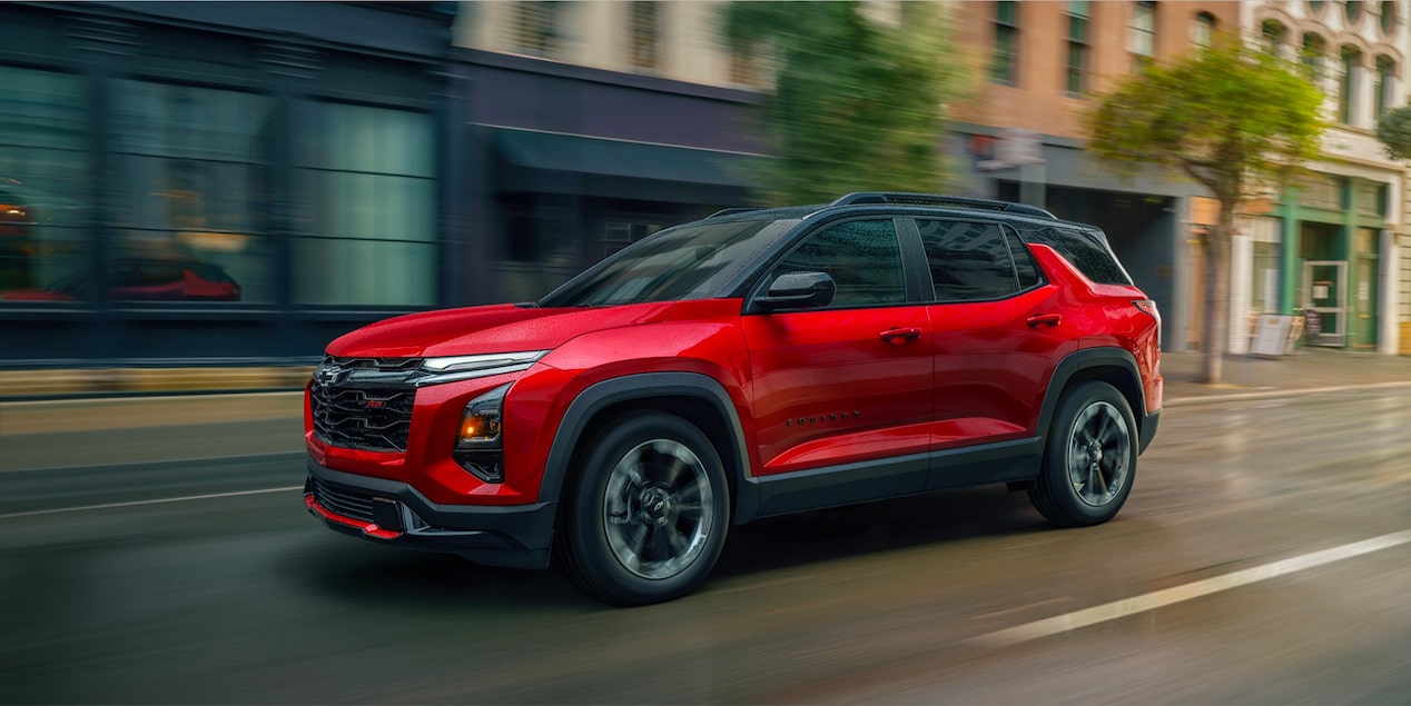 Front-side view of the 2026 Chevrolet Equinox driving fast alone in the city.