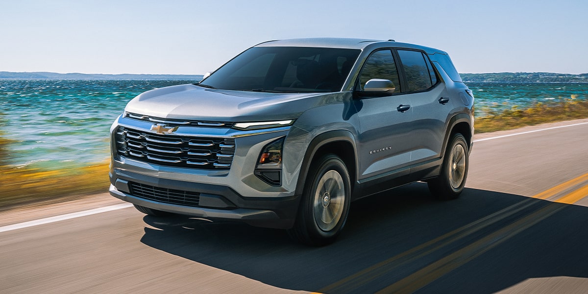 Front-side view of the 2026 Chevrolet Equinox driving on a seaside road.
