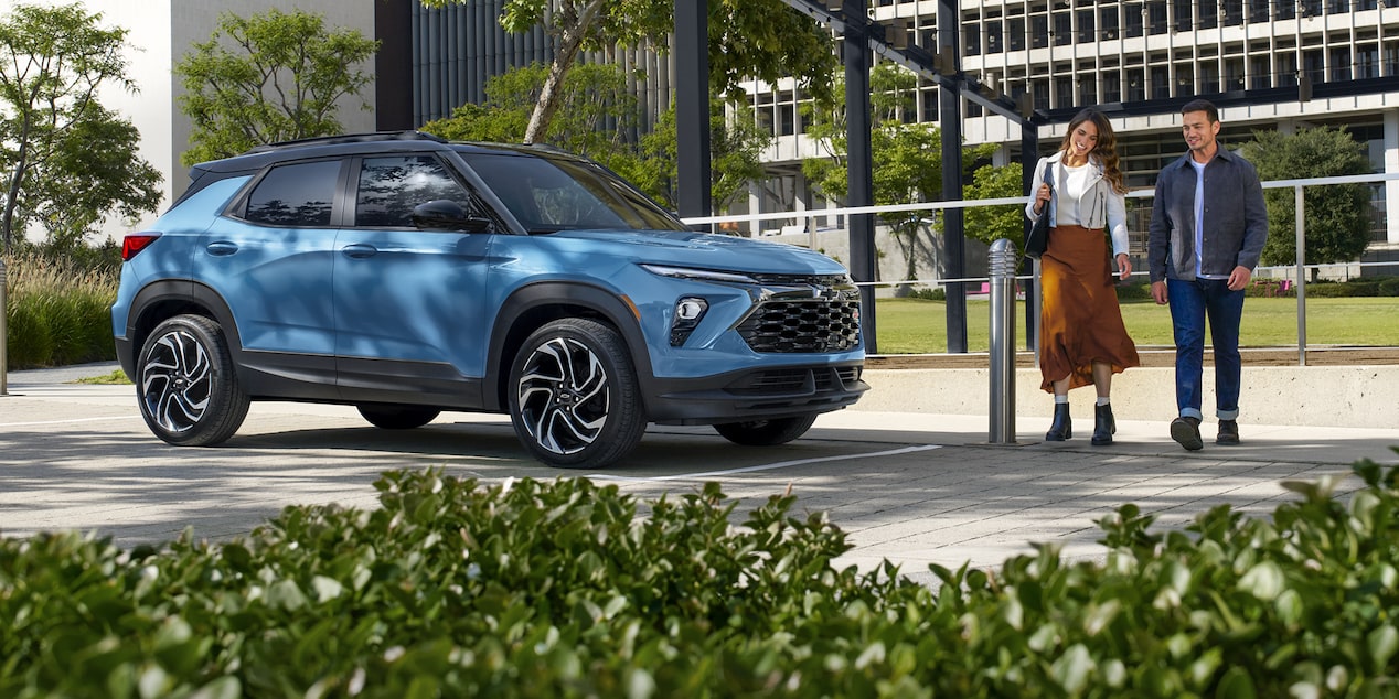Two people passing by a 2026 Chevrolet Trailblazer RS trim at a parking lot.
