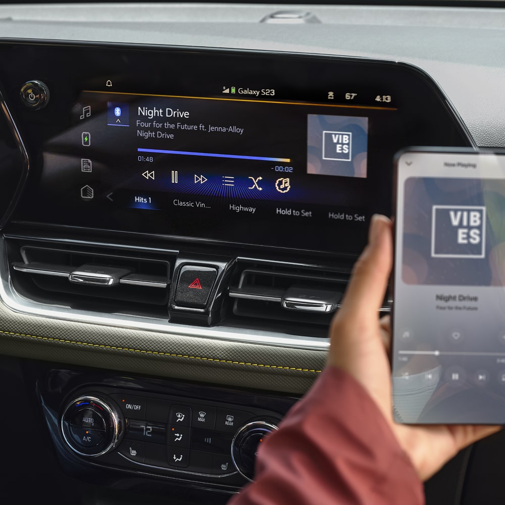 A passenger seated at the front row using a smartphone inside the 2026 Trailblazer.