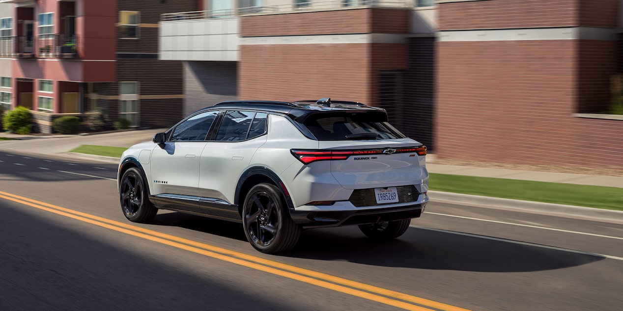 Back-side view of a 2025 Chevrolet Equinox EV driving down the road.