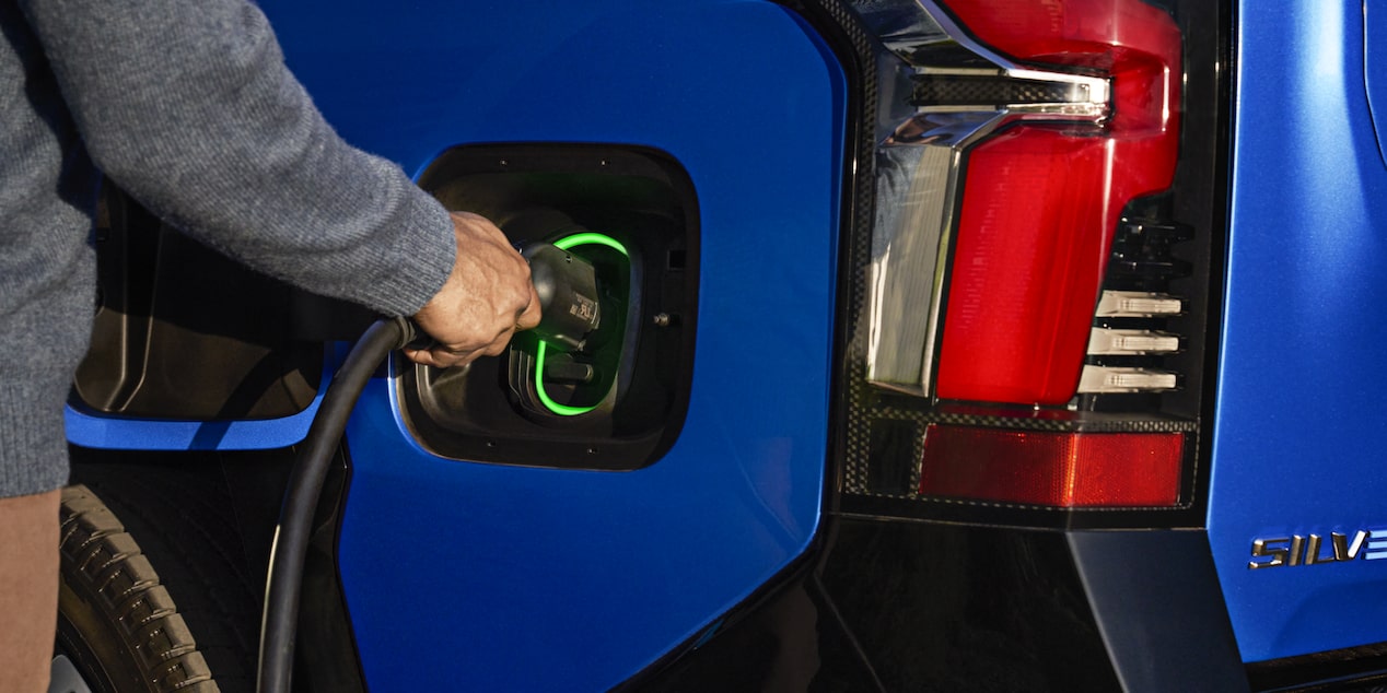 Une personne branche le Chevrolet Silverado EV 2025 dans un chargeur.