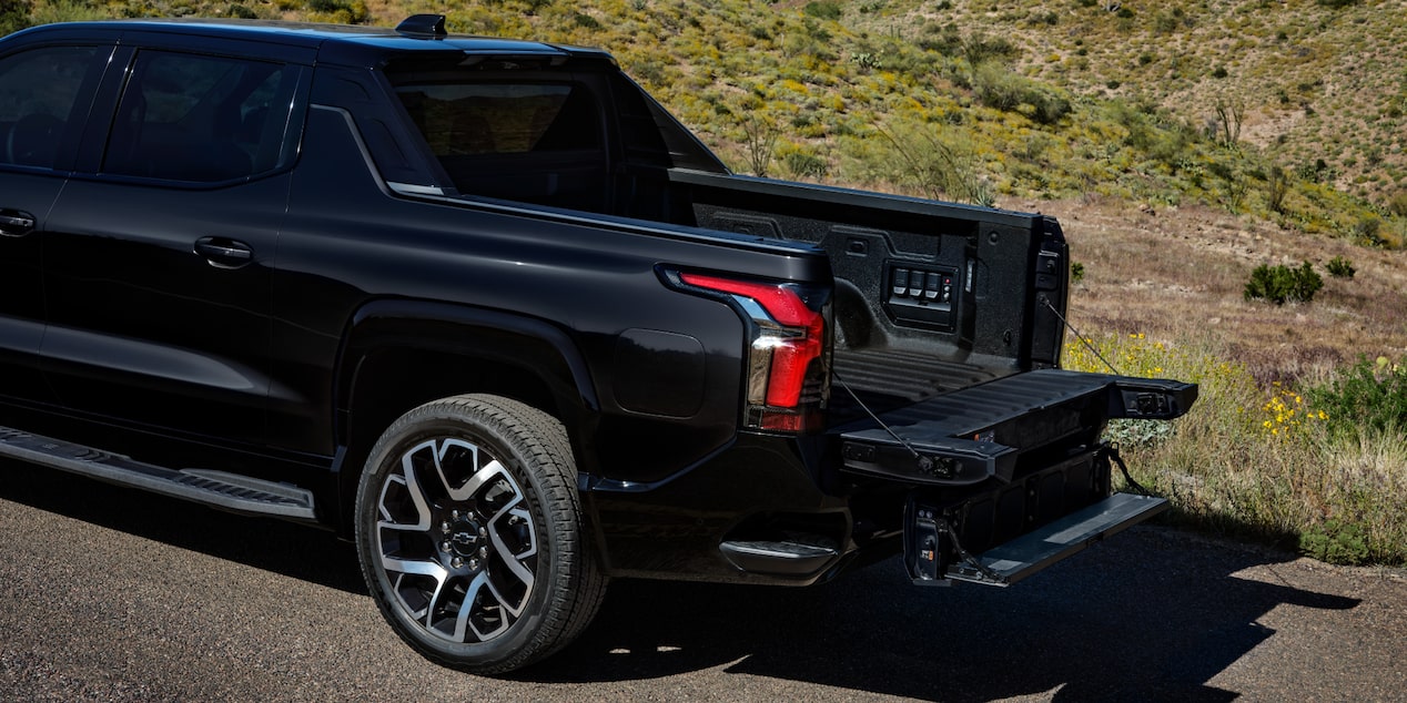 Vue latérale arrière du coffre d’un Chevrolet Silverado EV 2025 stationné par une journée ensoleillée.