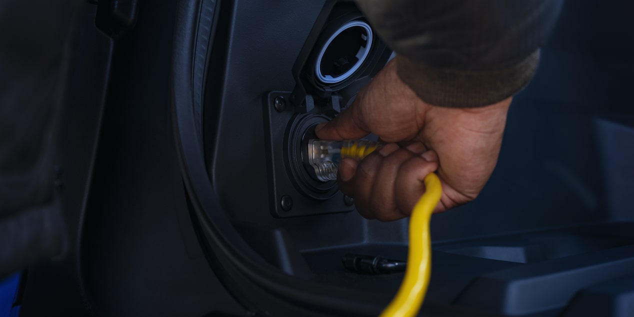Une personne branche le port de recharge du Chevrolet Silverado EV 2025.
