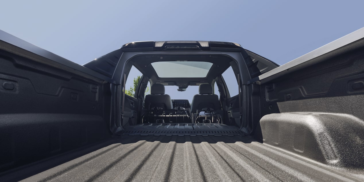 Vue à hauteur des yeux de la caisse du Chevrolet Silverado EV 2025 par une journée ensoleillée.
