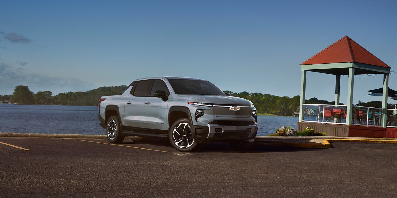 Front-side view of a 2025 Chevrolet Silverado EV with mountains in the distance.