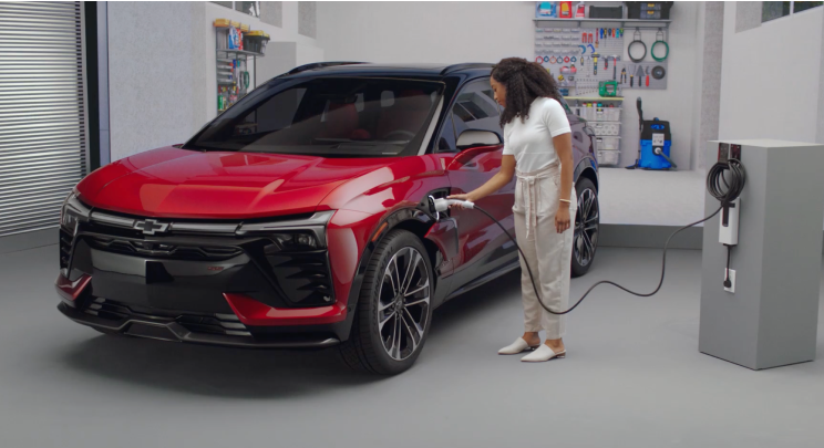 A person charging the 2026 Chevrolet Blazer EV at a home garage.