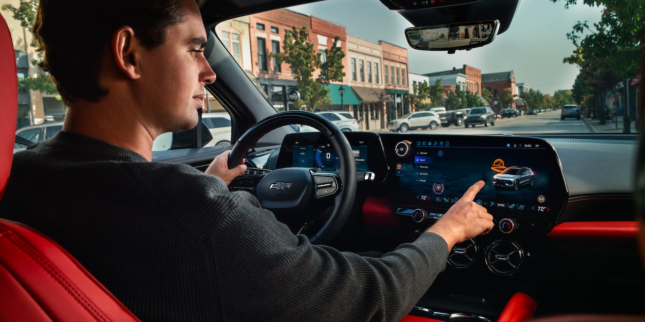 A person pressing the infotainment screen inside the 2026 Chevrolet Blazer EV.