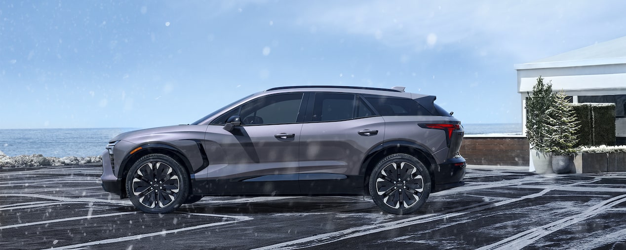 Chevrolet Blazer EV side profile while parked on a snowy driveway.
