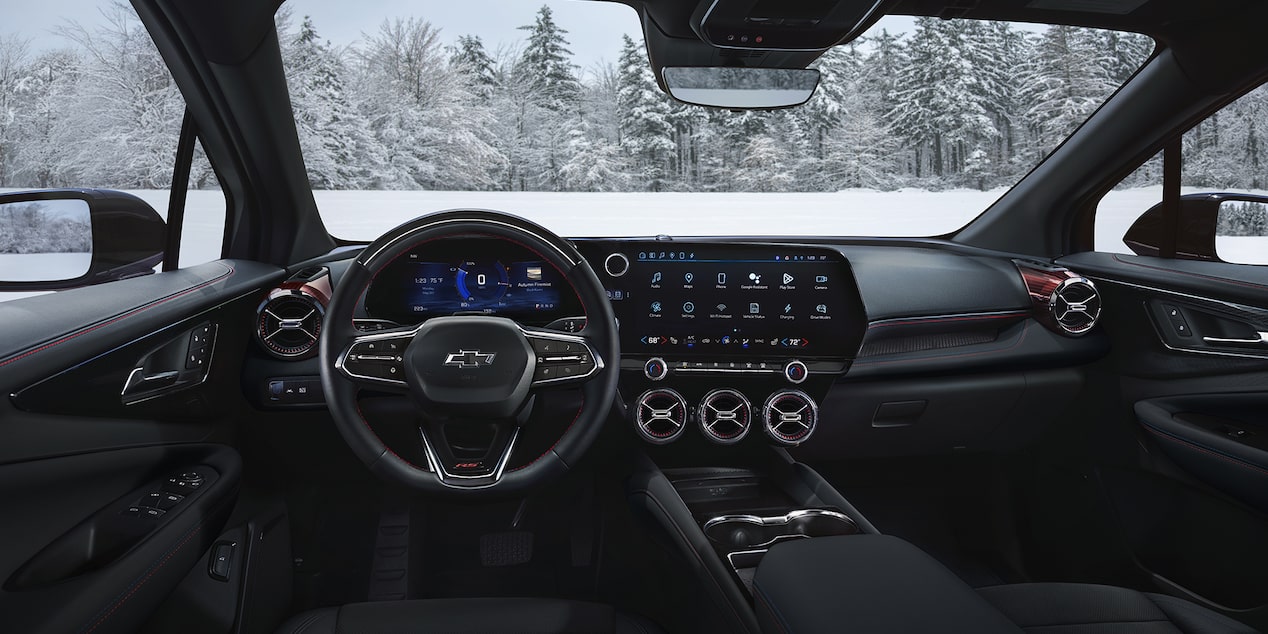 Interior dashboard view of Chevrolet Blazer EV with a snowy forest outside.