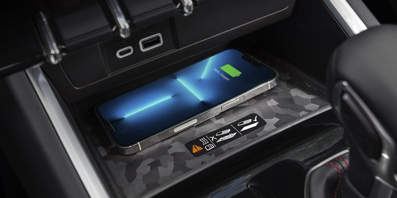 Close-up view of an iPhone charging on a wireless charger inside the 2025 Chevrolet Colorado.
