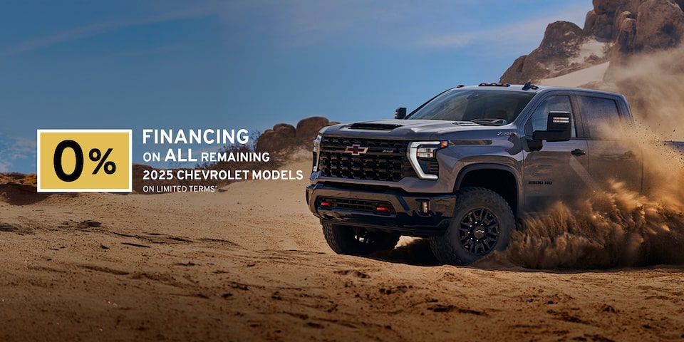 Front-side view of the 2025 Chevrolet Silverado HD pickup truck skidding in a sandy terrain.