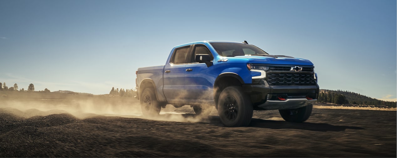 2026 Chevrolet Silverado LD driving on a dusty terrain.