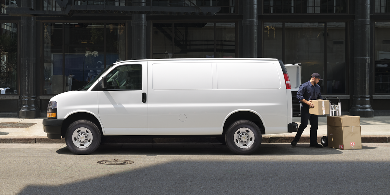 Un homme retire des boîtes de sa fourgonnette commerciale Chevrolet Express 2025.