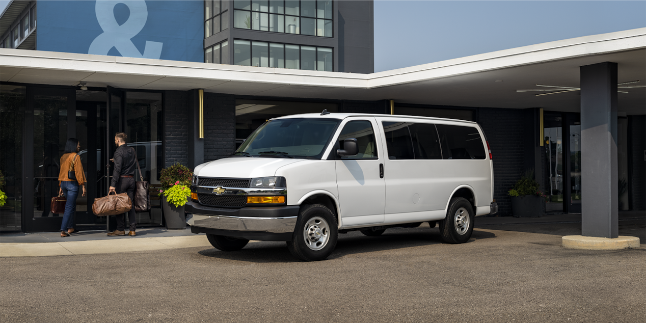 Une fourgonnette de tourisme Chevrolet Express 2025 dépose une famille à un hôtel.