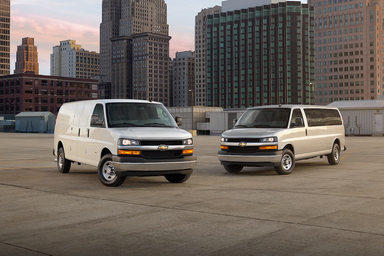 Deux fourgonnettes commerciales Chevrolet Express 2025 stationnées sur un toit en ville.