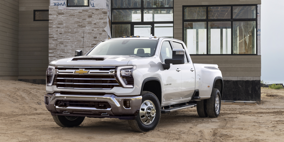 Vue latérale avant du camion de travail Chevrolet Silverado HD 2025 stationné devant une maison.