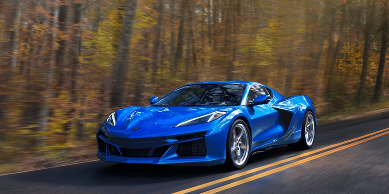 Blue Corvette E-Ray driving through woods