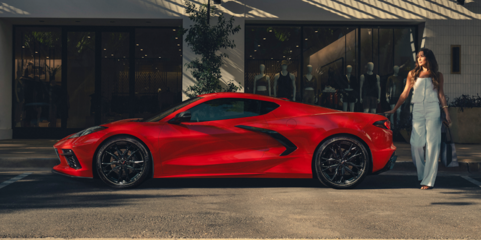 Side profile shot of a red Corvette Stingray parked on the street